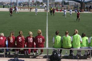 Elite club soccer players sit on the bench.