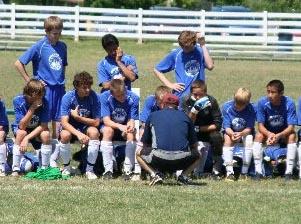 Elite club socer players sit on the socer bench.