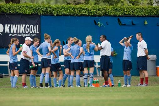 Elite club soccer players huddle.